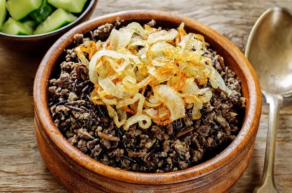 Porridge made with wild rice and black lentils with fried onions