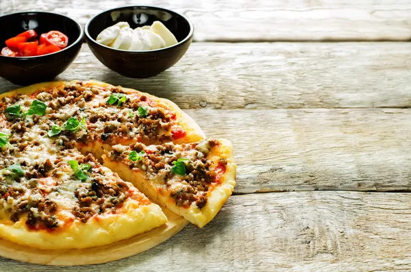 Pizza with meat, mozzarella and oregano