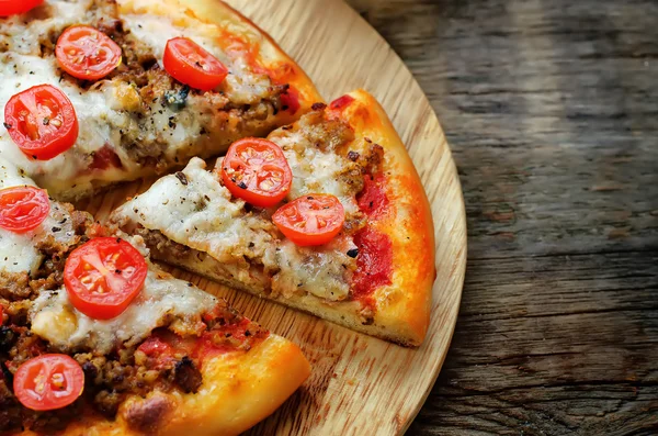 Pizza with meat, mozzarella and tomatoes