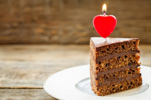 Chocolate cake with candles in the shape of a heart