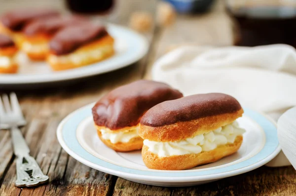 Eclairs with cheese cream and chocolate glaze