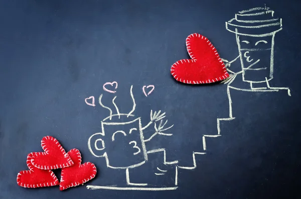 Cups of coffee with toy hearts drawn on the chalkboard