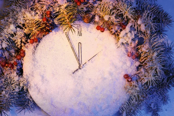 Large clock covered with snow before the new year