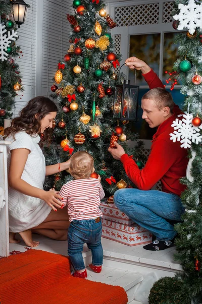 Young family decorating a Christmas tree