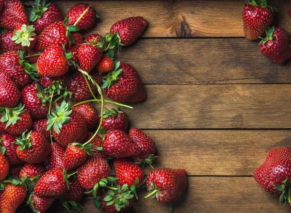 Strawberries over natural wooden background