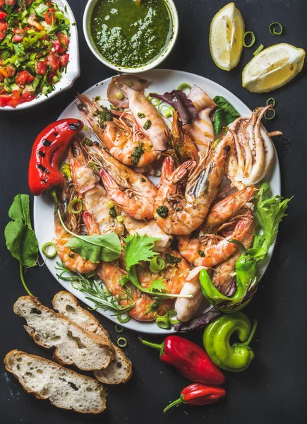 Plate of roasted seafood with salad and sauce