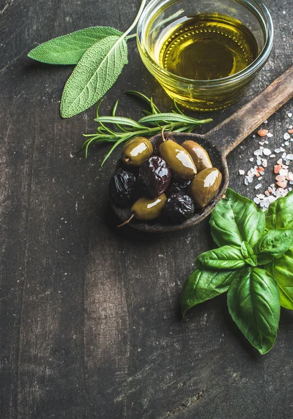 Green and black Mediterranean olives with fresh herbs