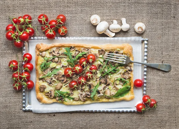 Rustic square mushroom pizza with fresh arugula and cherry-tomat