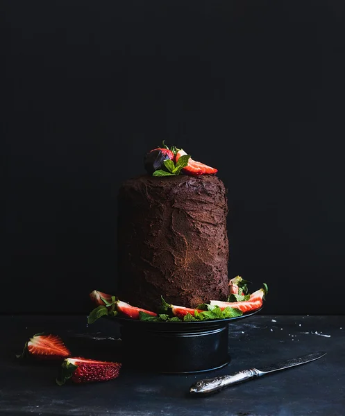 Chocolate high cake with strawberry, dark background