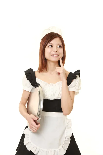 Young Japanese woman wearing french maid costume thinks about something