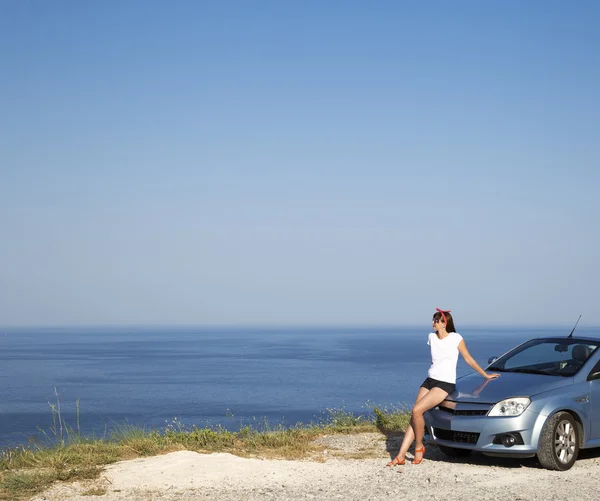 Young woman drive a car on the beach.
