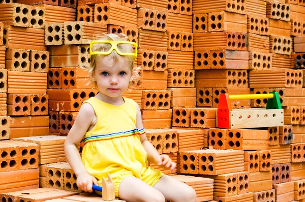 Smiling child with hard hat and construction box