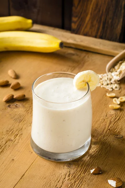 Banana smoothie / banana milkshake on wooden background