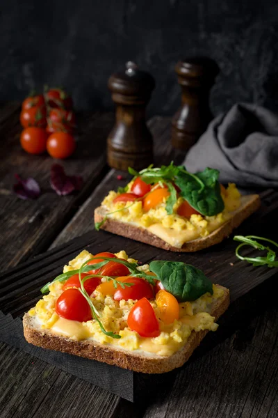 Toast with scrambled eggs, cheese, tomatoes and green salad