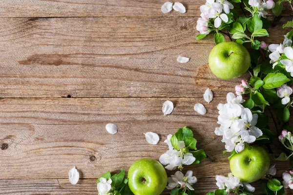 Summer post card. Blossoms, green apples and flowers on wooden backdrop