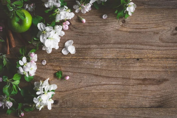 Moody summer post card: Blossoms, green apples and flowers on wooden backdrop