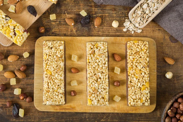 Granola bars, muesli bars, snack energy bars on wooden cutting board