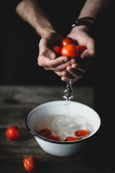 Washing tomatoes. Male chef washing tomatoes. Tomatoes in hands
