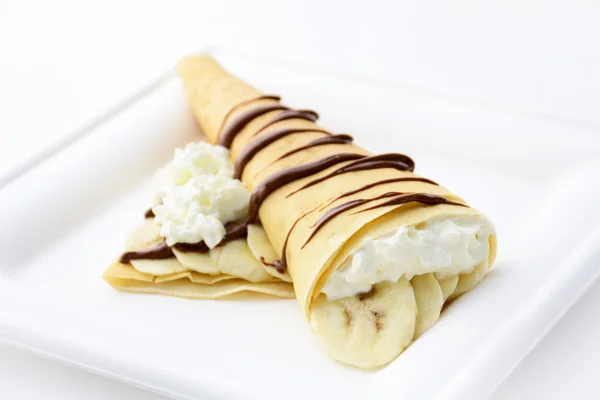 Crepe with banana, whipped cream and chocolate syrup
