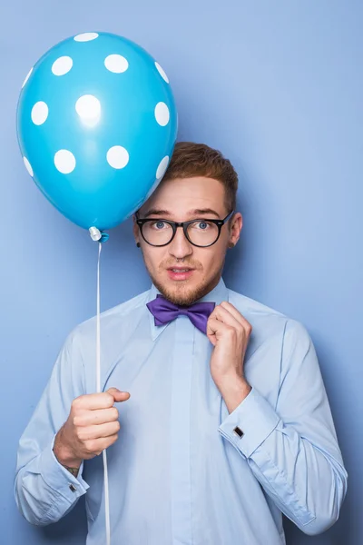 Attractive young man with a blue balloon in his hand. Party, birthday, Valentine