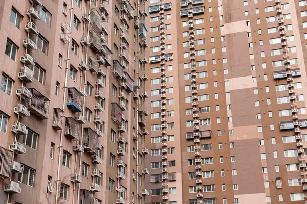 Large apartment house. Air conditioners hang on a wall.