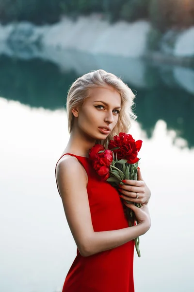 Pretty woman with a bouquet of peony. On the background