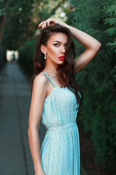 Fashion portrait of a beautiful girl in a turquoise dress