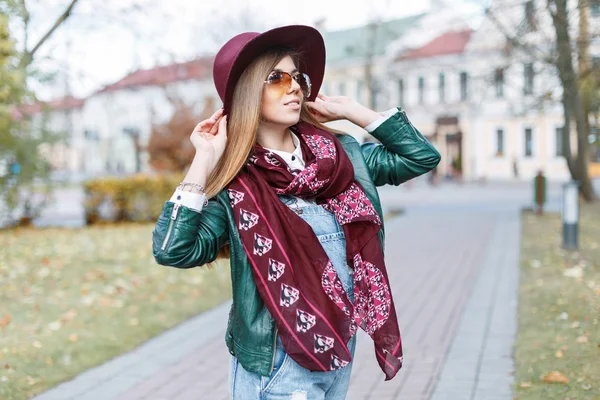 Beautiful woman posing at autumn day. Girl wearing fashionable sunglasses and hat.