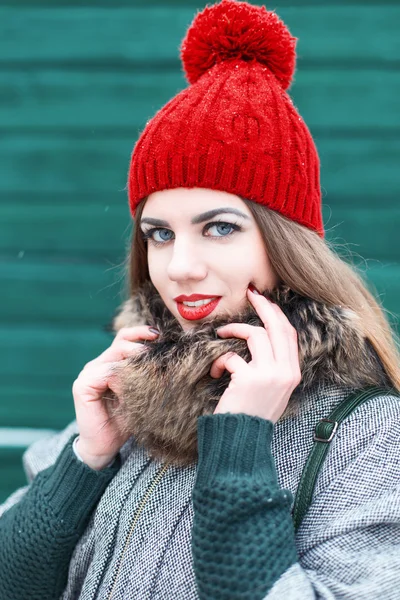 Young beautiful girl in retro style with a smile on a background of green wall