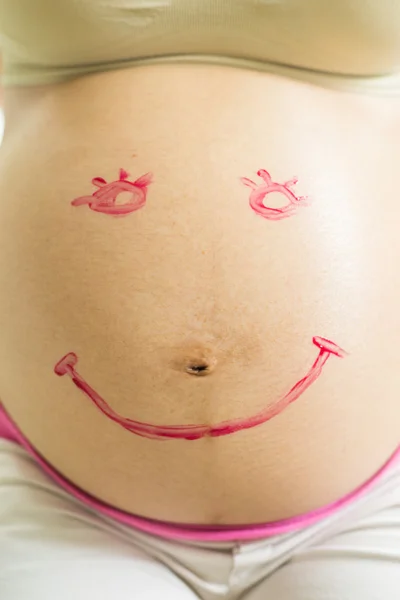 Smile Paint on pregnant woman abdomen