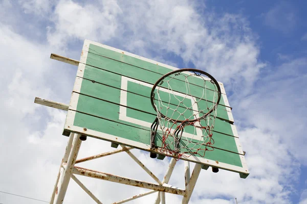 A basketball basket on weathered green wooden facade. Basketball