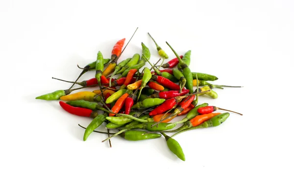 Red and green and orange chilli peppers on white background