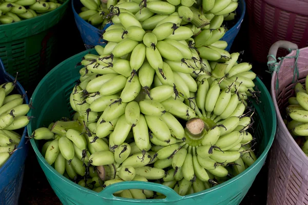 Green banana bundle in basket ready to sell
