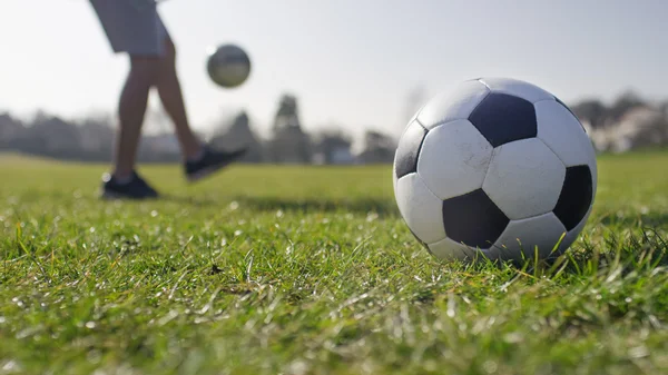 Football player doing kick ups in the park