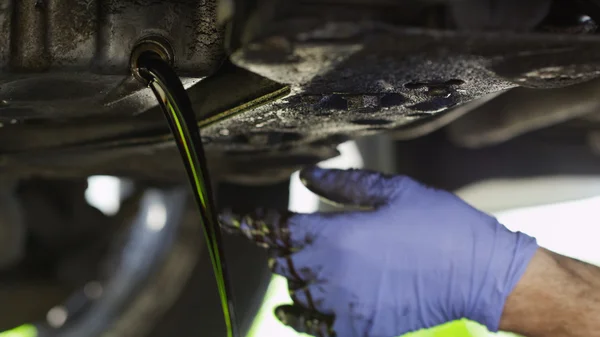 Dirty oil being drained from a car