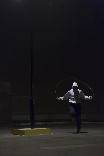Athlete skipping at night with a jump rope