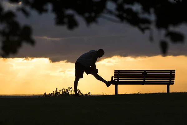 Silhouette of a man near the bench