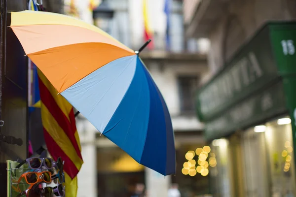 Colorful umbrella hanging along a narrow alley of shops