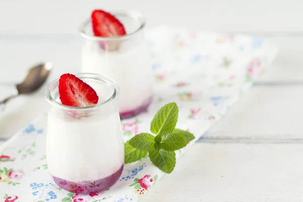 Fresh Organic Greek Yogurt with strawberries and jam on table