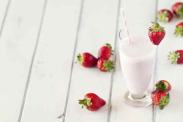 Strawberry milkshake with a straw in a glass