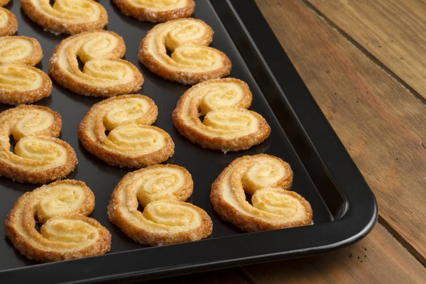Delicious puff pastry heart cookies on a baking tray