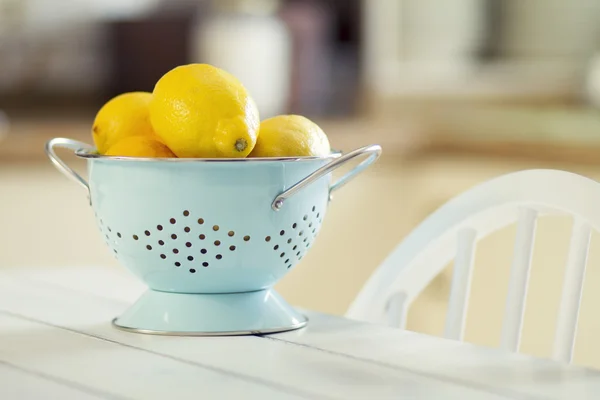 Some lemons in a turquoise colander