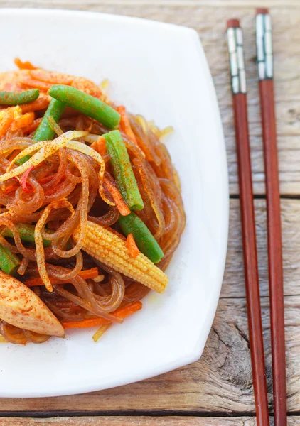Spicy glass noodles with chicken, green beans, carrots, corn and soy sprouts. Oriental cuisine