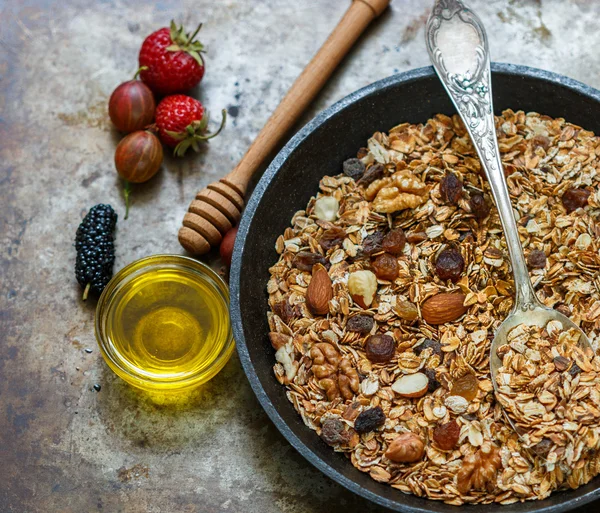 Homemade granola with raisins, walnuts, almonds and hazelnuts. Muesli and honey . Fresh berries - raspberry, strawberry, gooseberry, mulberry. Healthy Breakfast