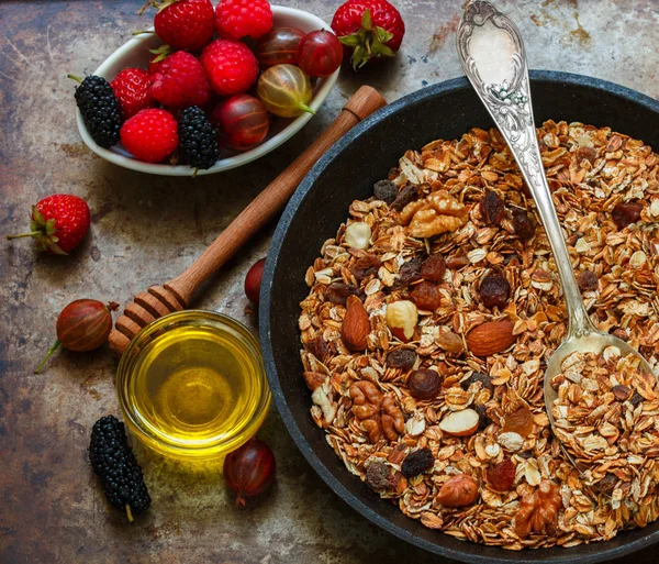 Homemade granola with raisins, walnuts, almonds and hazelnuts. Muesli and honey . Fresh berries - raspberry, strawberry, gooseberry, mulberry. Healthy Breakfast