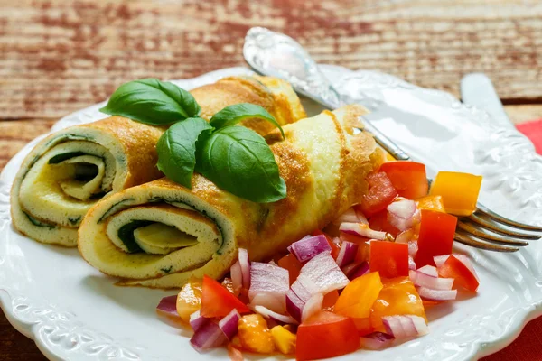 A traditional Breakfast. Omelette   with spinach and a fresh tomato salad, red onion and Basil. Roll scrambled eggs. Selective focus