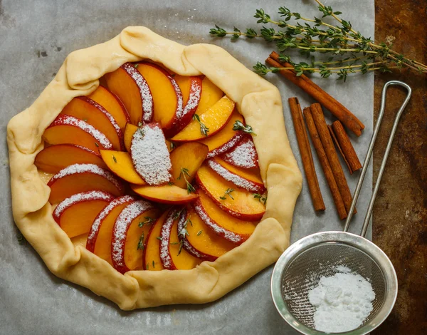Baking a fruit pie with peaches, nectarines. The ingredients on the table - dough, peaches, nectarines, sugar, cinnamon, thyme. Selective focus