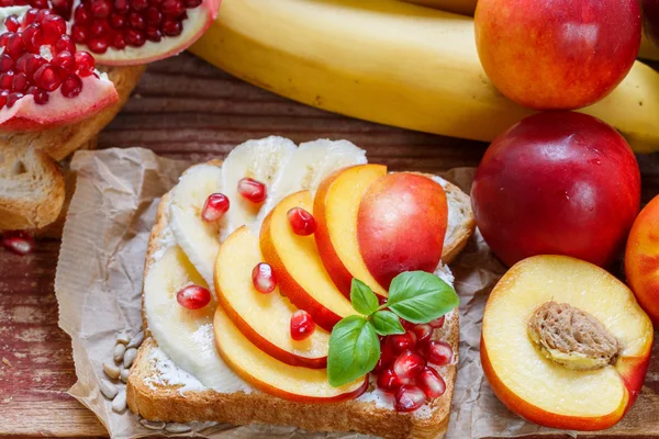 Healthy Breakfast. Dessert. Toast with cream cheese, banana, peach, nectarine and pomegranate