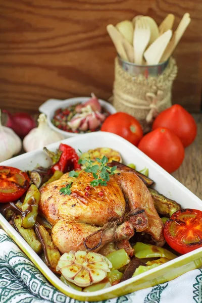 Baked chicken with vegetables and herbs. Dinner in a rustic styl