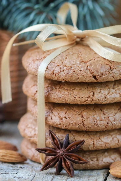 Spiced cookies with almonds. Christmas gifts. Round cookies, tied with ribbon and spruce branch in a basket on the table